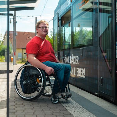 Rollstuhlfahrer an Haltestelle