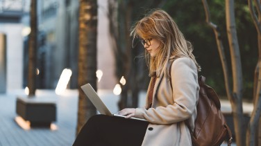 Frau mit Laptop kauft Tickets online