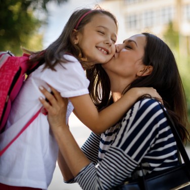 Mama verabschiedet Tochter zur Schule