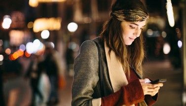 Frau nachts mit Smartphone in der Hand