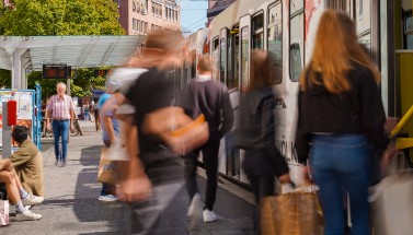 Fahrgäste steigen an Haltestelle in Straßenbahn
