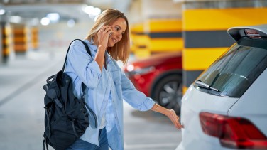 Frau am Kofferraum ihres Autos