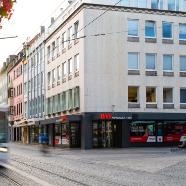 Straßenbahn fährt vor Kundenzentrum WVV